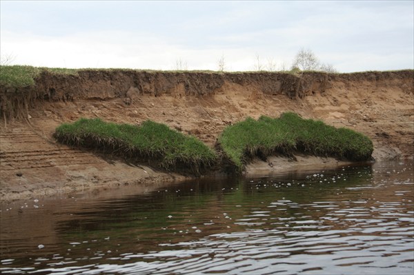 Травяные бровки берегов сползают в реку